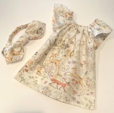 "This is such a charming little dress ...and if your baby girl is a bohemian, Anthropologie-esque sprite ...she will love wearing this! This lovely fabric depicts a series of woodland scenes ...with vintage drawings of animals in subtle shades of brown, grey, green, blue and pink. There are foxes and deer, raccoons and squirrels, birds, bunnies, butterflies and even frogs! The forest setting depicts ancient trees, trailing vines, delicate flowers and leaves ...and acorns and mushrooms, too :) Th Cute Summer Dress With Matching Headband, Cute Spring Dresses With Matching Headband, Fox Clothes, Fox And Deer, Bloomers Outfit, Vintage Drawings, Deer Dress, Forest Setting, Fox Dress