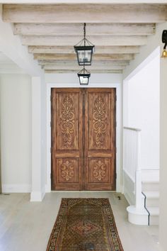 a large wooden door sitting in the middle of a hallway