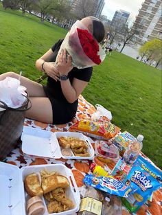 a woman sitting on the ground with food in front of her