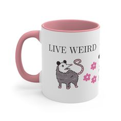 a pink and white coffee mug with an image of a rat on it