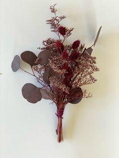 a bouquet of dried flowers on a white surface