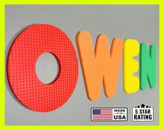 the word owen is made up of different colored plastic letters and numbers on a gray background