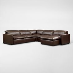 a large brown leather sectional sofa sitting on top of a white floor