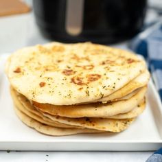 a white plate topped with flat bread on top of a table