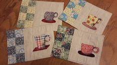 four quilted coasters with coffee mugs on them sitting on a wooden floor