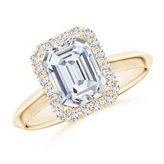 an emerald cut diamond ring set in yellow gold with diamonds around the band and shoulders