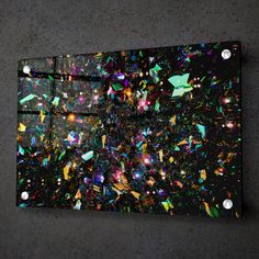 an abstract painting on the wall with lots of colored confetti all over it