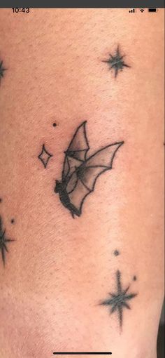 a small tattoo on the side of a woman's stomach with stars around it