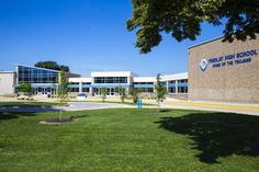 the front of a school building with grass and trees