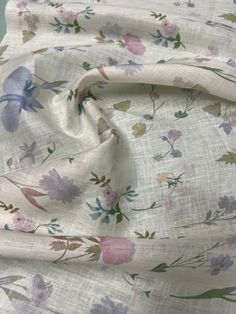 the fabric has flowers on it and is white