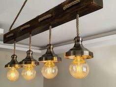 five light fixtures hanging from a beam in a room