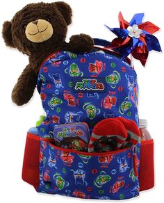 a teddy bear sitting on top of a blue backpack filled with candy and candies