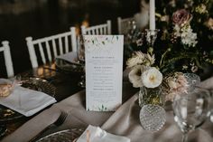 the table is set with flowers and place settings