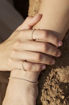 two hands holding each other on top of dirt