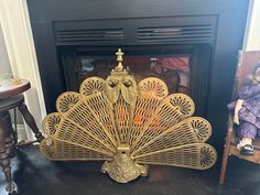 a golden peacock statue sitting on top of a table in front of a fire place