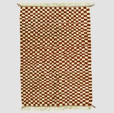 a brown and white checkered rug with fringes