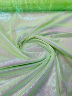 a green and pink fabric with metallic foiling on it's edges, as well as the background