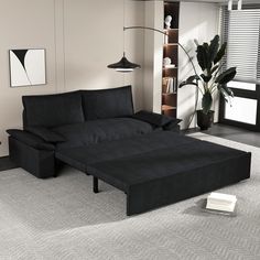 a living room with a black couch and book shelf