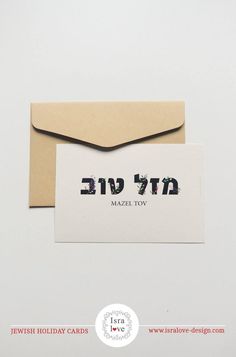 a card with the word mazil tov written in hebrew on it next to an envelope