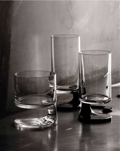 three glasses sitting on top of a table next to each other and one is empty