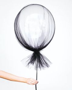 a woman holding a black and white balloon