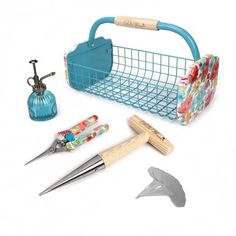 a blue basket with scissors and other crafting tools in it on a white background