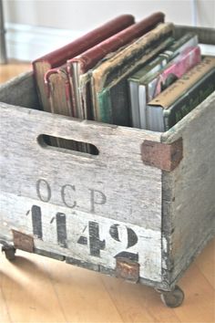 an old wooden crate filled with books on top of a hard wood floor