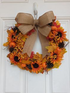 a fall wreath with sunflowers and pine cones