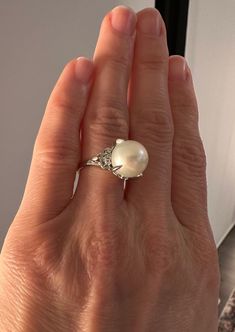 Materials: Platinum Ring Size: 6.25  Hallmarks: D009 Pt900  Total Weight (grams): 7.80  Primary Stone(s) Type: Cultured Pearl  Primary Stone(s) Shape: Near-Round  Primary Stone(s) Dimensions: 11.60 mm - approximate (very large pearl - significant in size) Primary Stone(s) Gemologist Note: White with pink and green overtone and the Cultured Pearl has excellent luster.  Secondary Stone(s) Type: Diamond  Secondary Stone(s) Shape: Round Brilliant Cut  Secondary(s) Stone Dimensions: 1.50 - 1.60 mm  T Classic White Gold Pearl Ring With Diamond Accents, Timeless White Gold Pearl Ring With Center Stone, Formal White Rings With Center Stone, Formal Brilliant Cut Pearl Ring, Elegant White Pear-shaped Diamond Ring, Formal White Pearl Ring With Center Stone, Brilliant Cut Diamond White Pearl Ring, Classic White Gold Pearl Ring With Prong Setting, Timeless White Gold Pearl Ring With Diamond Accents