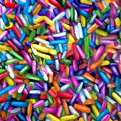 multicolored sprinkles are scattered on top of each other in this image