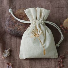 a bag with a dandelion drawn on it next to some rocks and leaves