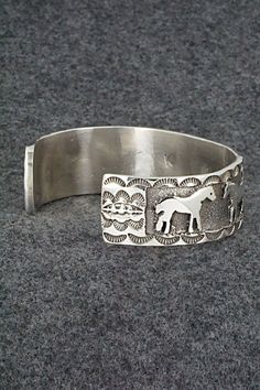 This sterling silver bracelet featuring horses was made by Navajo silversmith Preston Kinsel. The back is signed K and stamped sterling.Size: 5 5/8" (will fit up to a 6 7/8" wrist)Gap: 1 1/4"Width: 3/4"Free shipping on all orders! We ship with USPS and always include tracking. All orders ship within a day of payment.Returns are accepted up to 30 days after you receive your order. Just send us a message. Our shop offers cash back or store credit. The item must be returned in new condition. Adjustable Sterling Silver Horse Design Jewelry, Western Style Engraved Bracelets For Gifts, Adjustable Western Sterling Silver Bracelet, Silver Horse Design Bracelet Jewelry, Silver Horse Design Jewelry Bracelet, Silver Western Style Bracelet, Collectible Silver Horse Design Jewelry, Western Style Silver Bracelet For Gift, Western Style Silver Bracelets For Gift