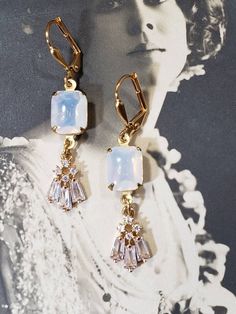 These Art Deco style earrings are inspired by the gorgeous opal and diamond jewelry worn during the 1920s. Sparkling clear rhinestone pendants dangle from white opal glass connectors. The earrings measure 1 3/4 inches long and hang from gold plated lever back ear wires. These elegant dangles are reminiscent of the geometric shaped rhinestone jewelry worn during the Jazz Age. Perfect for a Great Gatsby themed wedding or party. ABOUT THIS COLLECTION The sophisticated style of the Roaring Twenties 1920 Jewelry, Art Deco Jewelry 1920s, 1920s Earrings, Great Gatsby Themed Wedding, 1920s Jewelry, Earrings Bride, Great Gatsby Wedding, 1920 Fashion, Pearl Jewels