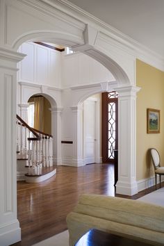 an open living room with white walls and wood floors, along with a staircase leading up to the second floor