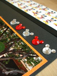 mickey mouse buttons are placed on the side of a card with trees in the background