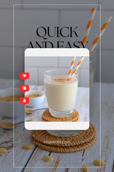 a glass filled with milk sitting on top of a table next to two straws