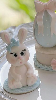 two little bunny figurines sitting on top of a plate