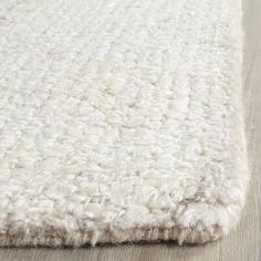 a white rug on top of a wooden floor