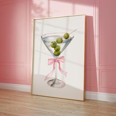 a painting of a martini glass with olives in it on a pink painted wall