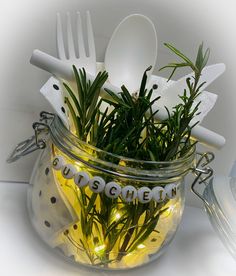 a glass jar filled with plastic utensils and plants