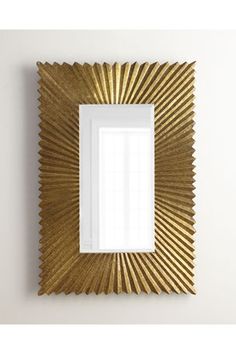 a gold framed mirror hanging on the wall