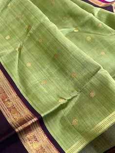 This beautiful saree in pistachio green shot black is handwoven. The rettai pettu border in betelnut shot with black color and purple selvedge is flanked in chakram and geometric motifs in gold zari. The body is adorned with chakram motifs while the grand pallu is decorated with paisleys along with traditional motifs in gold zari. Blouse piece is in betelnut shot with black color. Approximate Length 6.5 mtrs (inclusive of blouse length) Height - 46 - 52" Approximate weight - 1.6 lbs Saree comes Green Shot, Kanjivaram Silk Saree, Traditional Motifs, 40th Gifts, Silk Cotton Sarees, Geometric Motifs, Pistachio Green, Cotton Sarees, Blouse Length