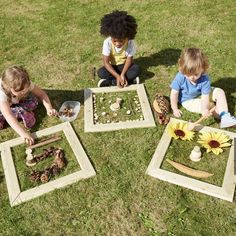 three children are playing with wooden squares and sunflowers on the grass in front of them