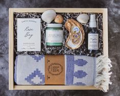 an open box containing sea shells, body care products and a towel