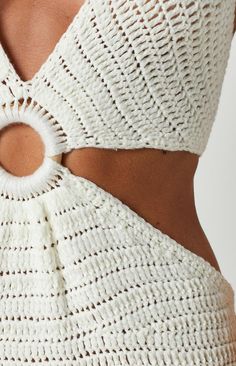 the back of a woman's white knitted top with a circular cutout