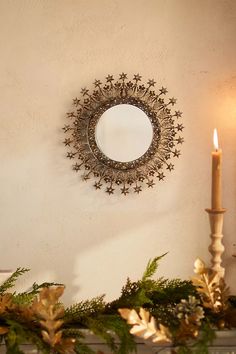 a mirror on the wall above a mantel with candles