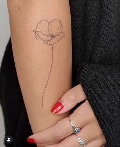 a woman's arm with a flower tattoo on the left side of her arm