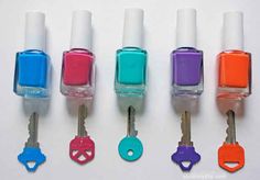 five different colors of nail polish are lined up in a row with keys attached to them