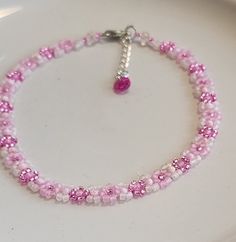 This dainty beaded anklet is made with quality, extra small Japanese and/or Czech seed beads with flowers in two shades of pink. In-between are small round pink beads. The ends are finished with faceted pink bicone beads and a silver filled extension chain with crystal charm. Anklet measures approximately 9.5" with additional 1" extender chain.  Protect from lotions and sprays and excessive contact with water. Cheap Pink Anklets For Festivals, Cheap Pink Round Beads Anklets, Cheap Pink Round Bead Anklets, Coquette Diy, Diy Choker, Charm Anklet, Beaded Anklet, Bead Choker, Pink Jewelry