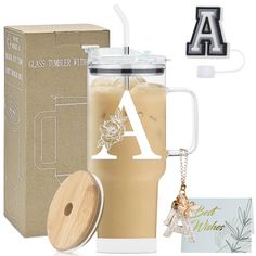 a glass tumbler with a wooden lid next to a cardboard box and keychain